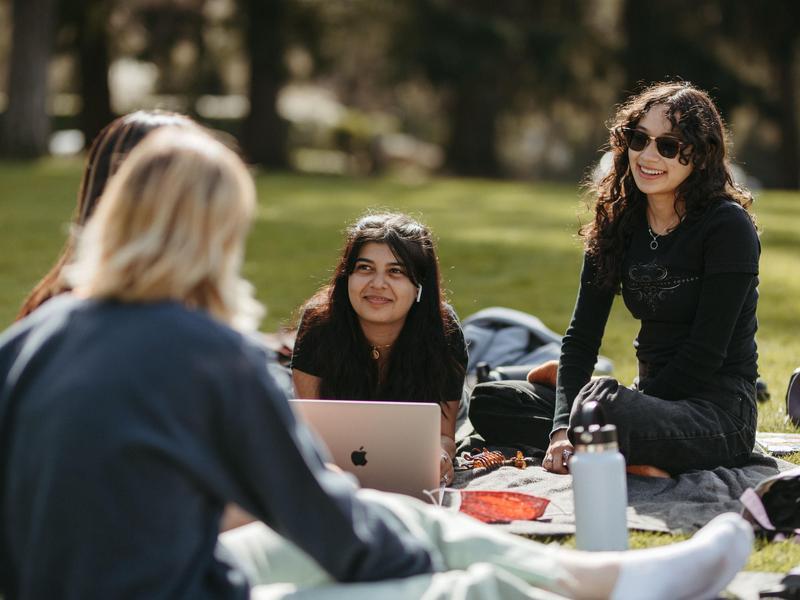 A small group of students relaxing together on the Great Lawn.